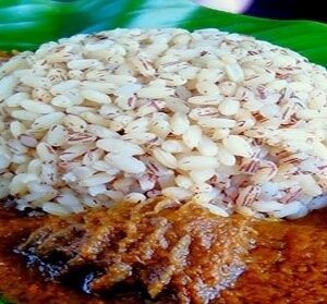 A plate of rice and meat on a green leaf.