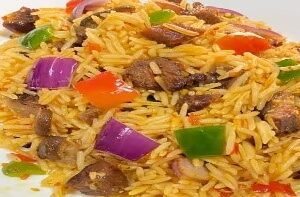 A plate of rice with meat and vegetables.