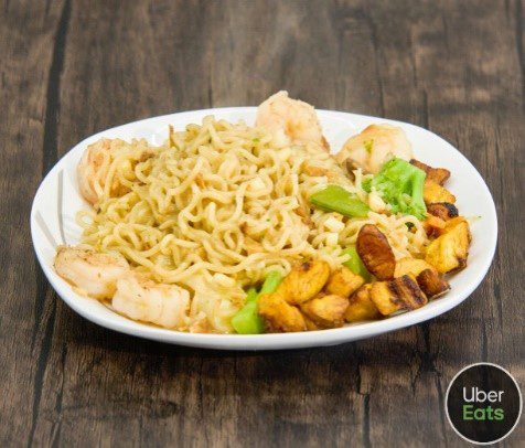 A plate of noodles and vegetables on top of a table.