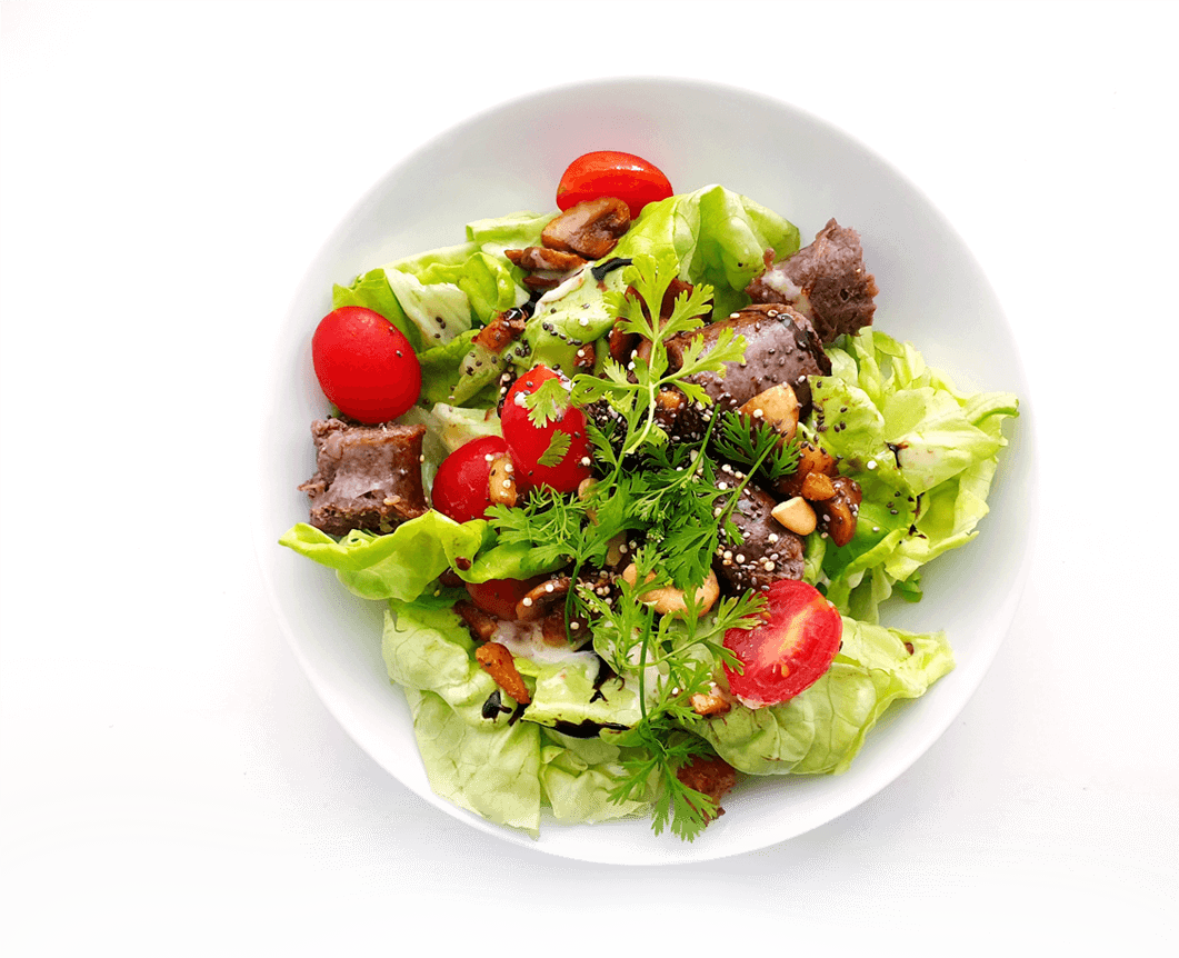 A salad with meat and vegetables in it.