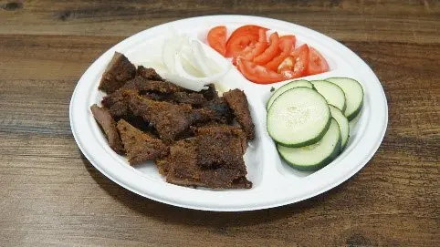 A plate of food with meat, vegetables and sauce.