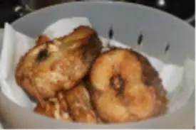 A bowl of food with some fried bananas.